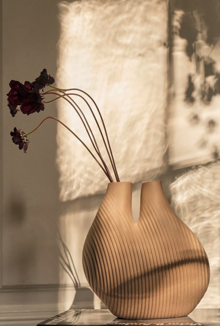 matte light brown vase in a sculpted shape with a ridged line design