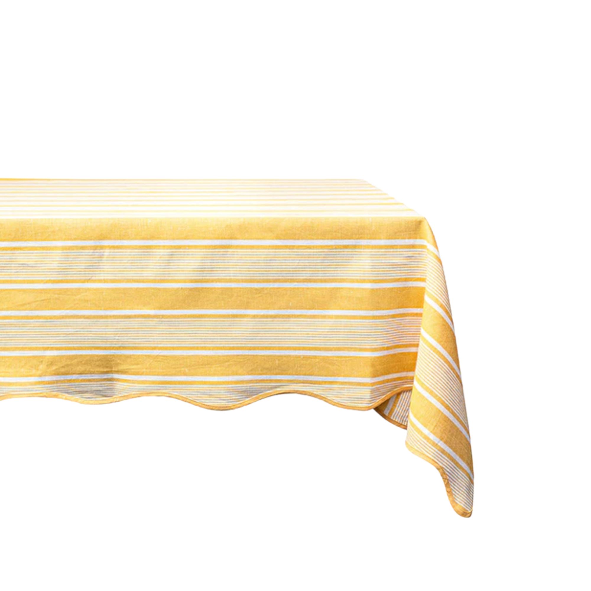 A yellow and white striped tablecloth with a scalloped trim