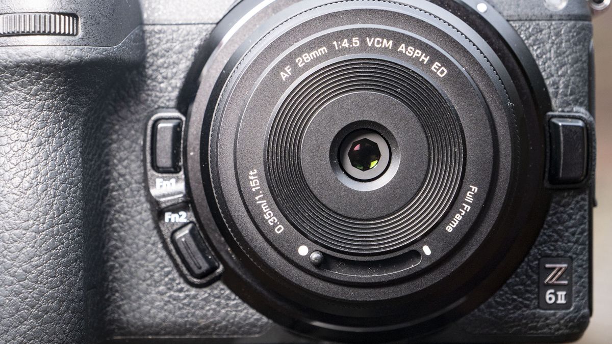 Closeup of the Viltrox AF 28mm f/4.5 body cap lens, protector removed