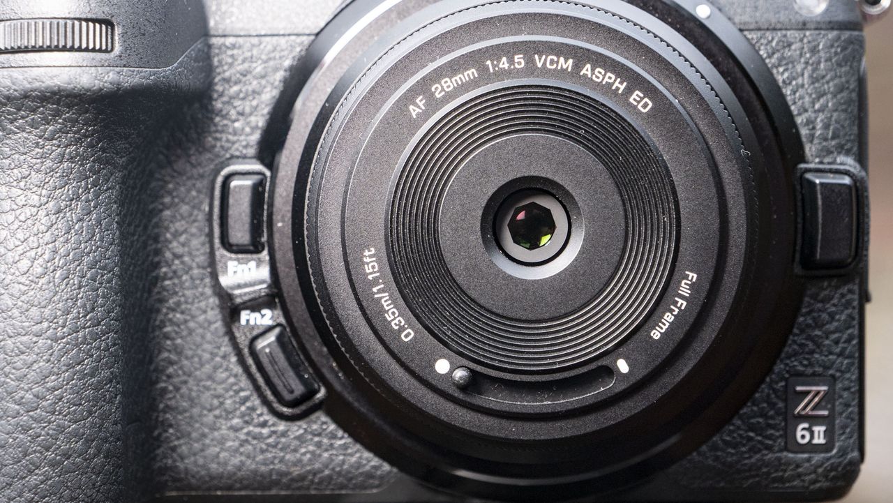 Closeup of the Viltrox AF 28mm f/4.5 body cap lens, protector removed