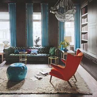 living room with orange armchair and green sofaset