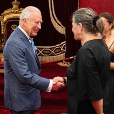 King Charles shaking hands with a woman