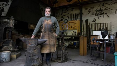 Portrait of confident blacksmith in his workshop