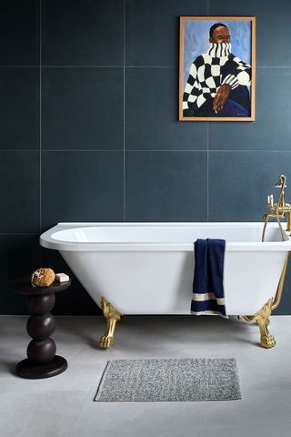 blue bathroom with white tub and artwork