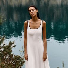 Woman wears white dress with black piping