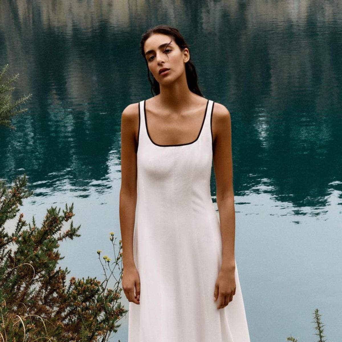 Woman wears white dress with black piping 