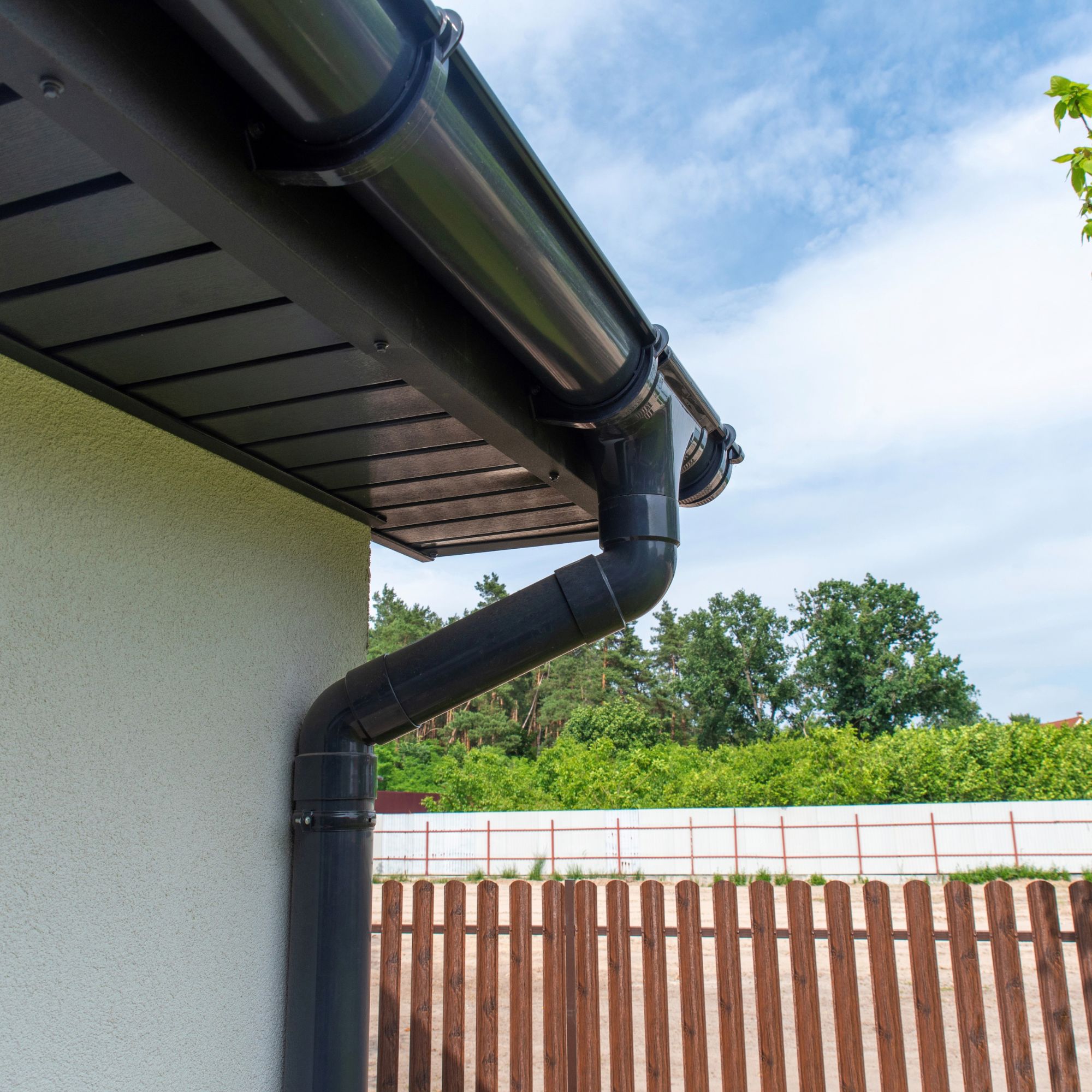 Plastic gutter on eaves of house
