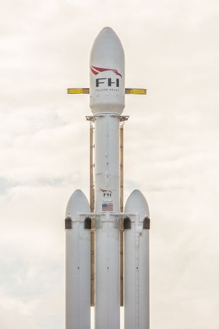 A close-up of the Falcon Heavy’s upper stage and payload fairing, which cocoons a red Tesla roadster.