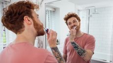 A man brushing his teeth with one of the best electric toothbrushes