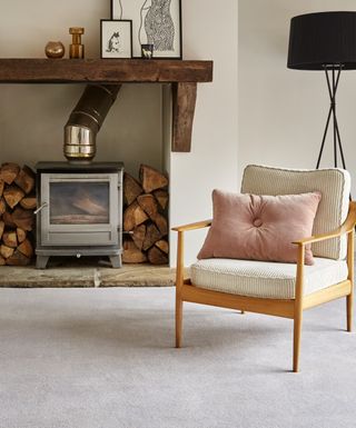 Pale gray carpet in a neutral scheme with log burner illustrating ideas to decorate small spaces.