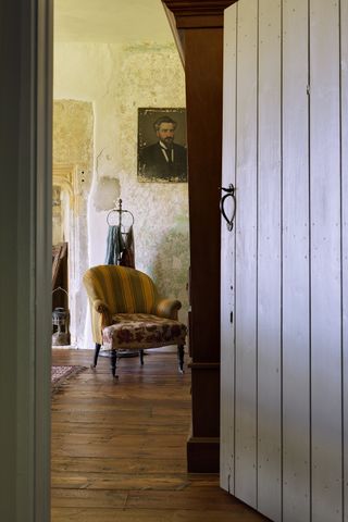 wooden door opening into living room with orange armchair