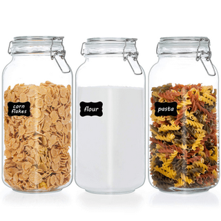 3 Airtight Glass Jars With Lids and chalk labels filled with corn flakes, flour and pasta