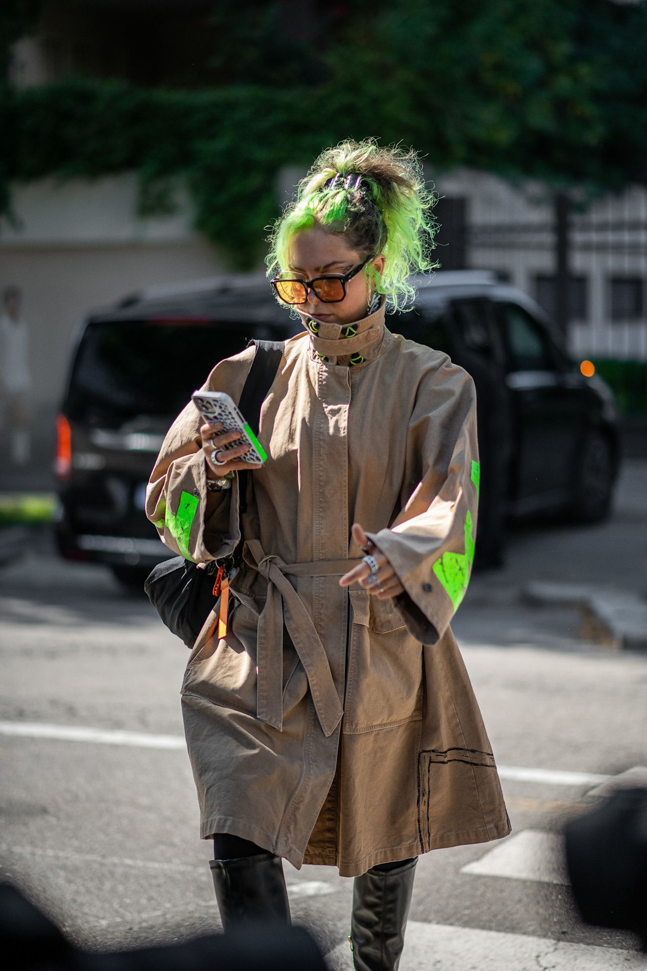 a white woman with green hair in a tan jacket