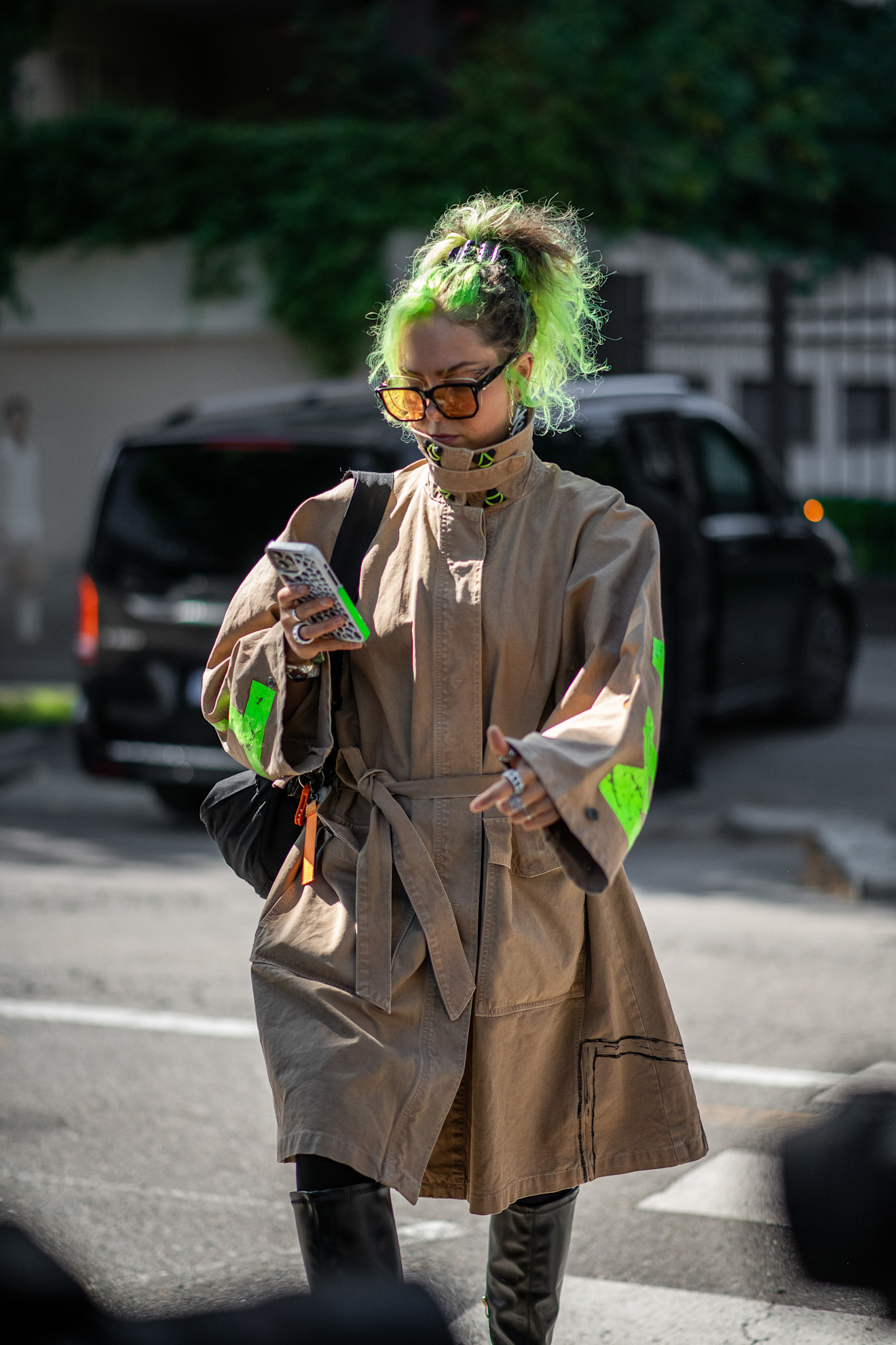 a white woman with green hair in a tan jacket