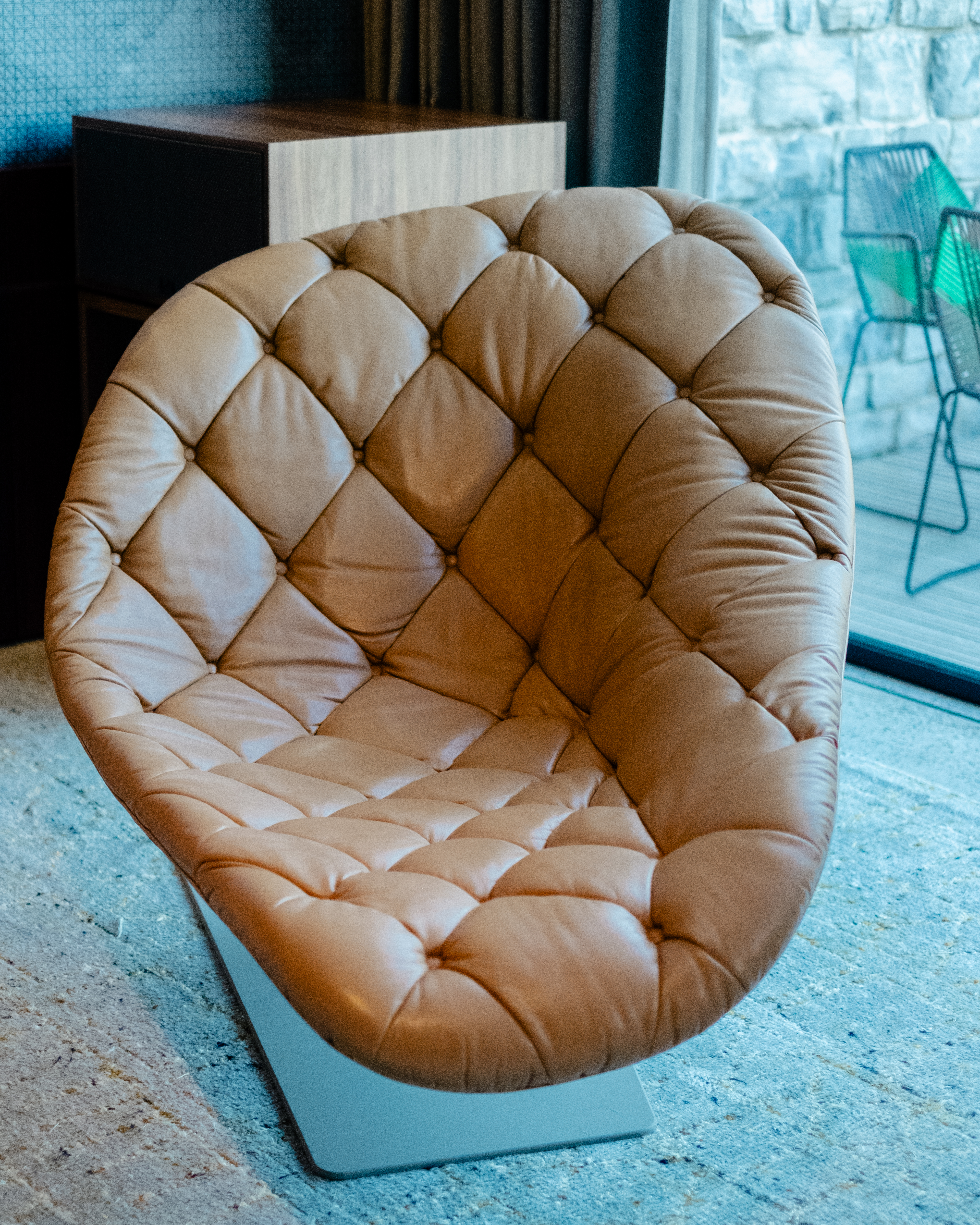A mid-century modern-inspired hotel suite features earthy-tinted interiors, colorful design collectibles, and plenty of music equipment.