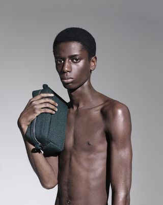 Model holding Raf Simons Kvadrat wash bag