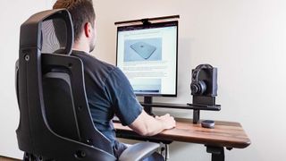 A person working without distractions on a desk setup built around the Oakywood Standing Desk Pro and the LG DualUp monitor