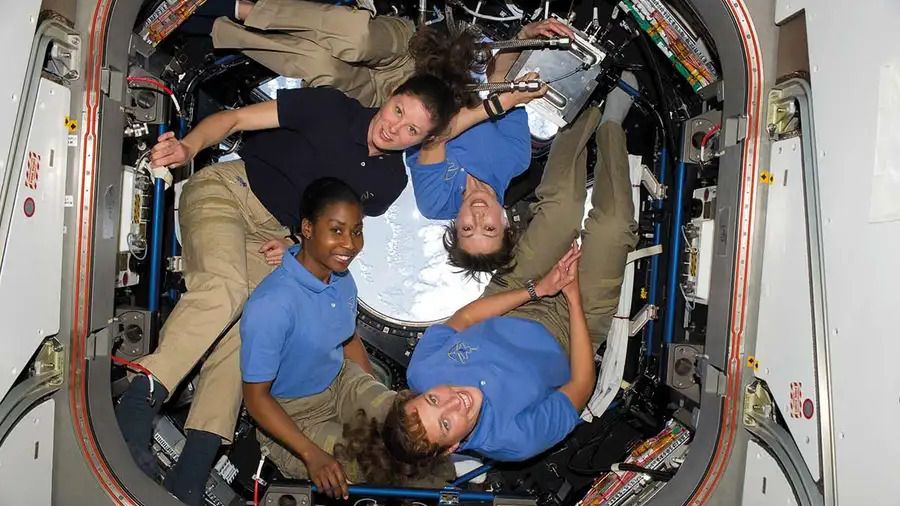 4 women in the international space station smiling at the camera