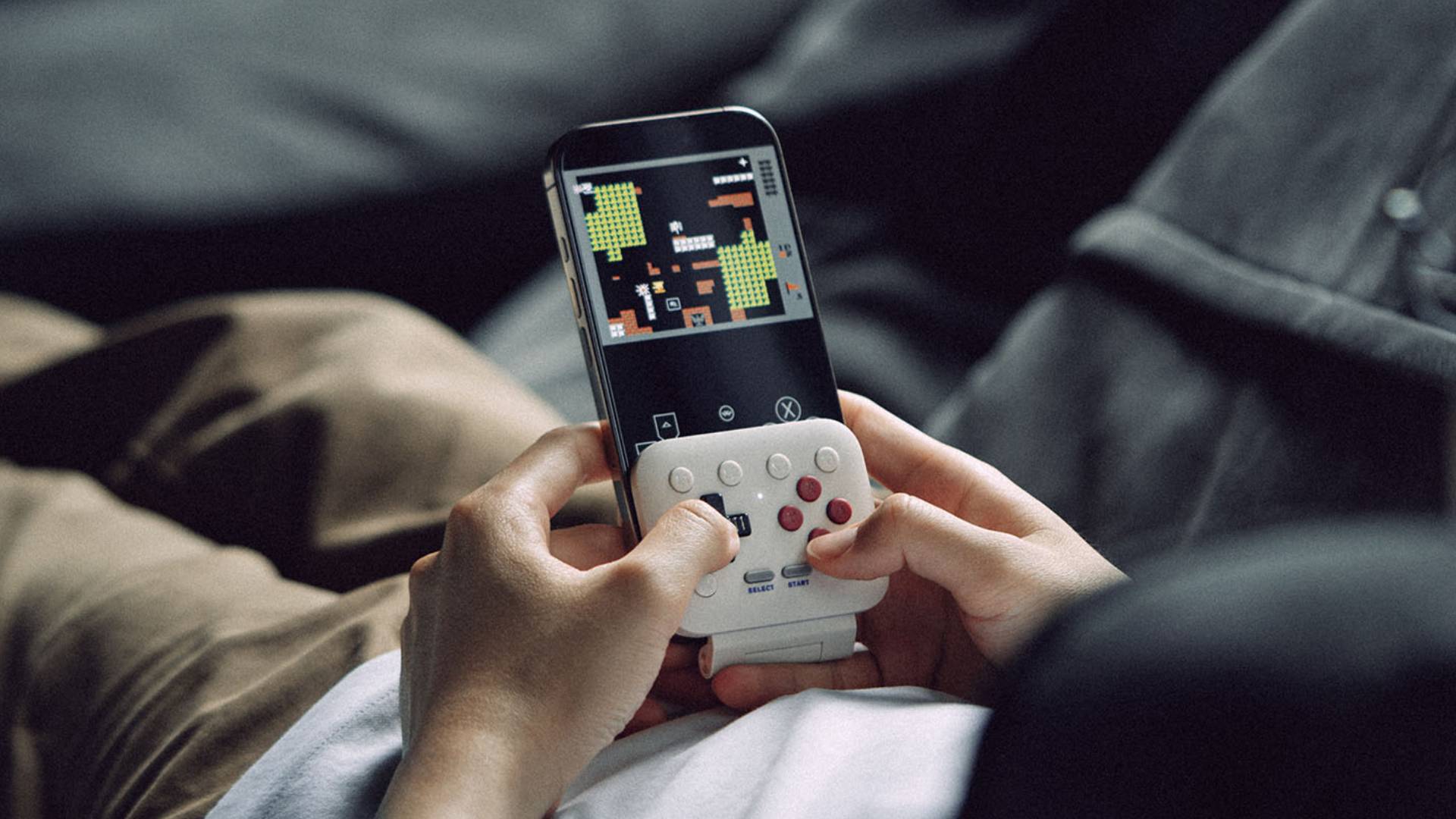 Player lying down using 8Bitdo FlipPad to play Game Boy games.