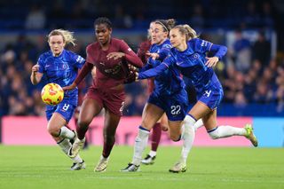 Khadija 'Bunny' Shaw of Manchester City battles for possession with Nathalie Bjorn, Lucy Bronze and Erin Cuthbert of Chelsea during the Barclays Women's Super League match between Chelsea and Manchester City at Stamford Bridge on November 16, 2024 in London, England.