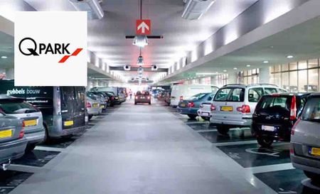 q-park logo placed over an image of cars parked in a parking lot