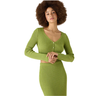 woman wearing a green cropped ribbed cardigan and matching skirt