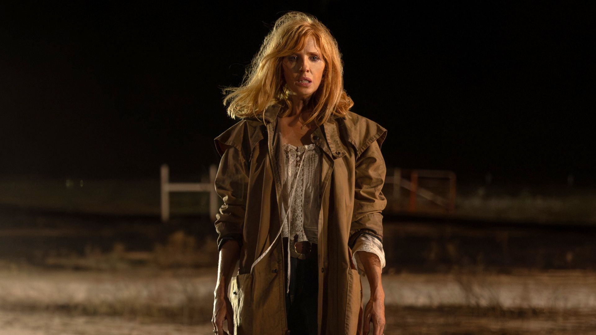Beth Dutton stands in the middle of the road at nighttime