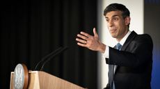 Prime Minister Rishi Sunak gesturing while standing at a podium