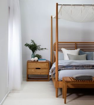A four poster bed with a fabric on top