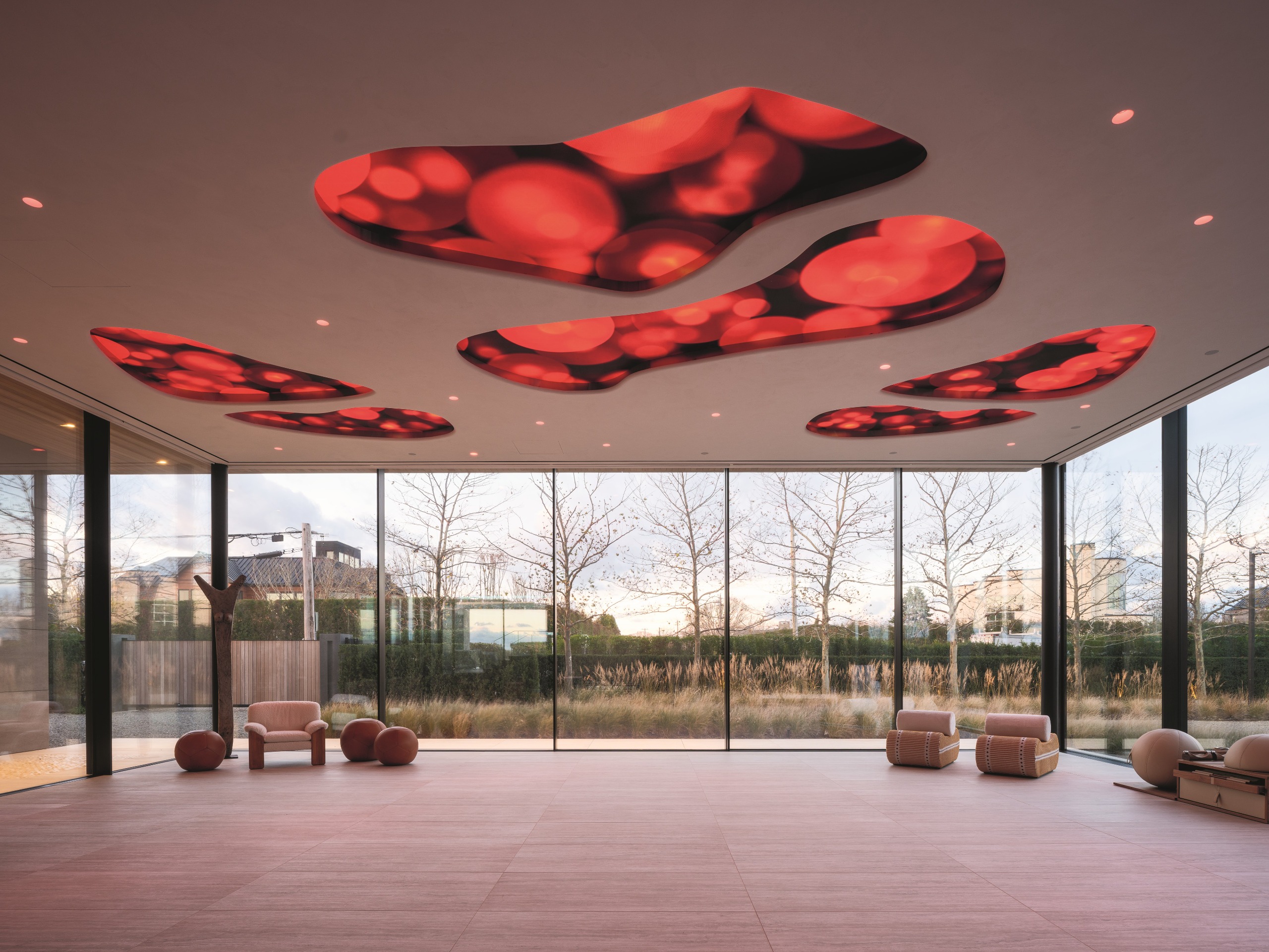 Theatrical interiors with art installation-like ceilings, a consistent yet striking palette, statement lighting in bold forms, and softly shaped furniture.