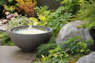 small rock garden ideas: bowl shaped stone water feature