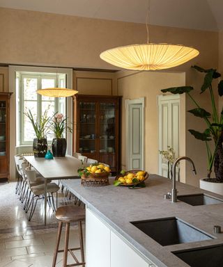 A kitchen and dining room with two hanging light fixtures