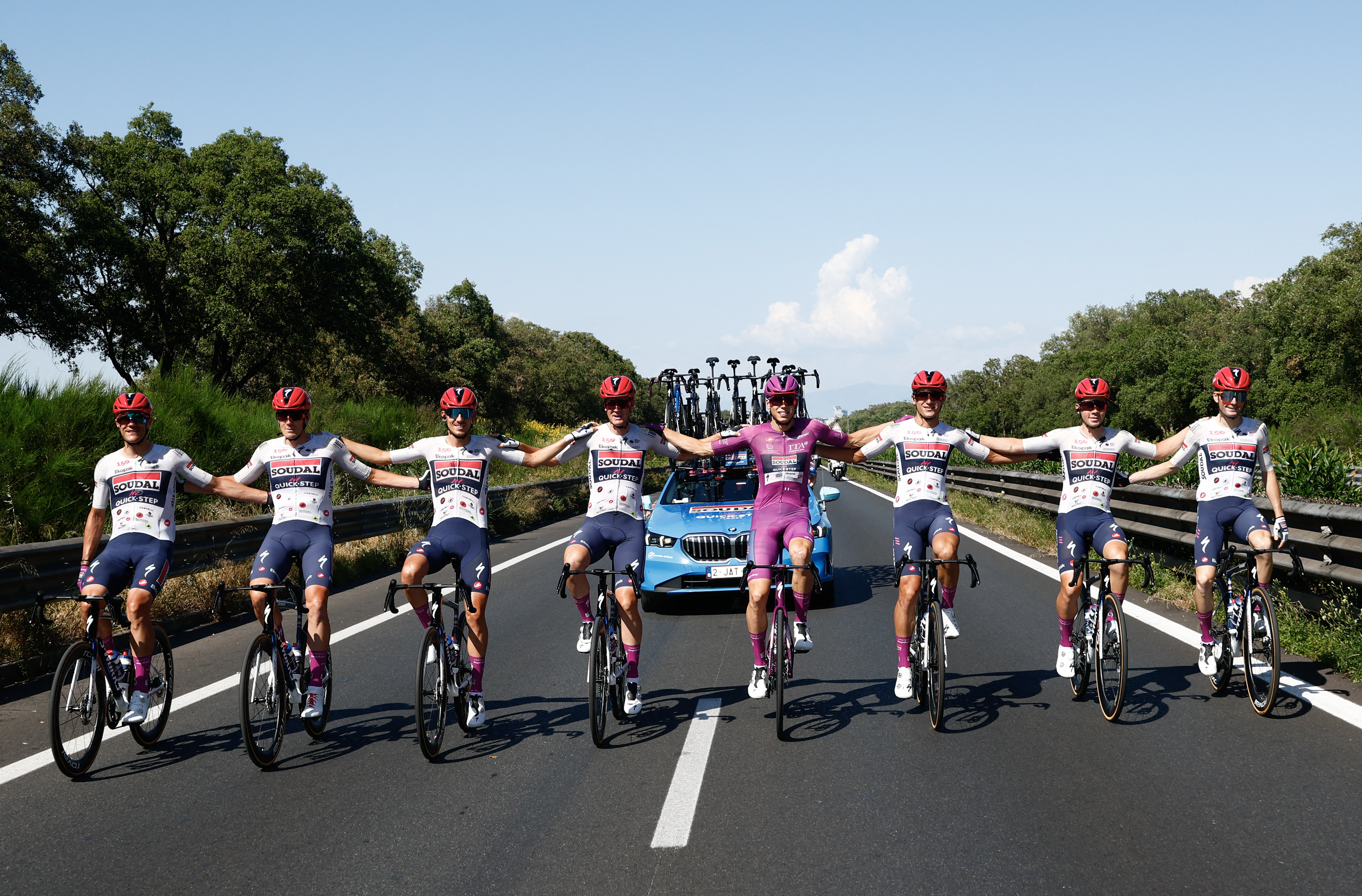 Soudal Quick-Step French rider Paul Magnier best sprinter's cyclamen jersey rides flanked by his teammates during the 21th stage of the Giro d'Italia 2026 - Tour of Italy cycling race of 131km from Rome to Rome, Italy, on May 31, 2026. (Photo by Luca Bettini / AFP)