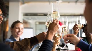 Group of people clinking glasses at Christmas with champagne