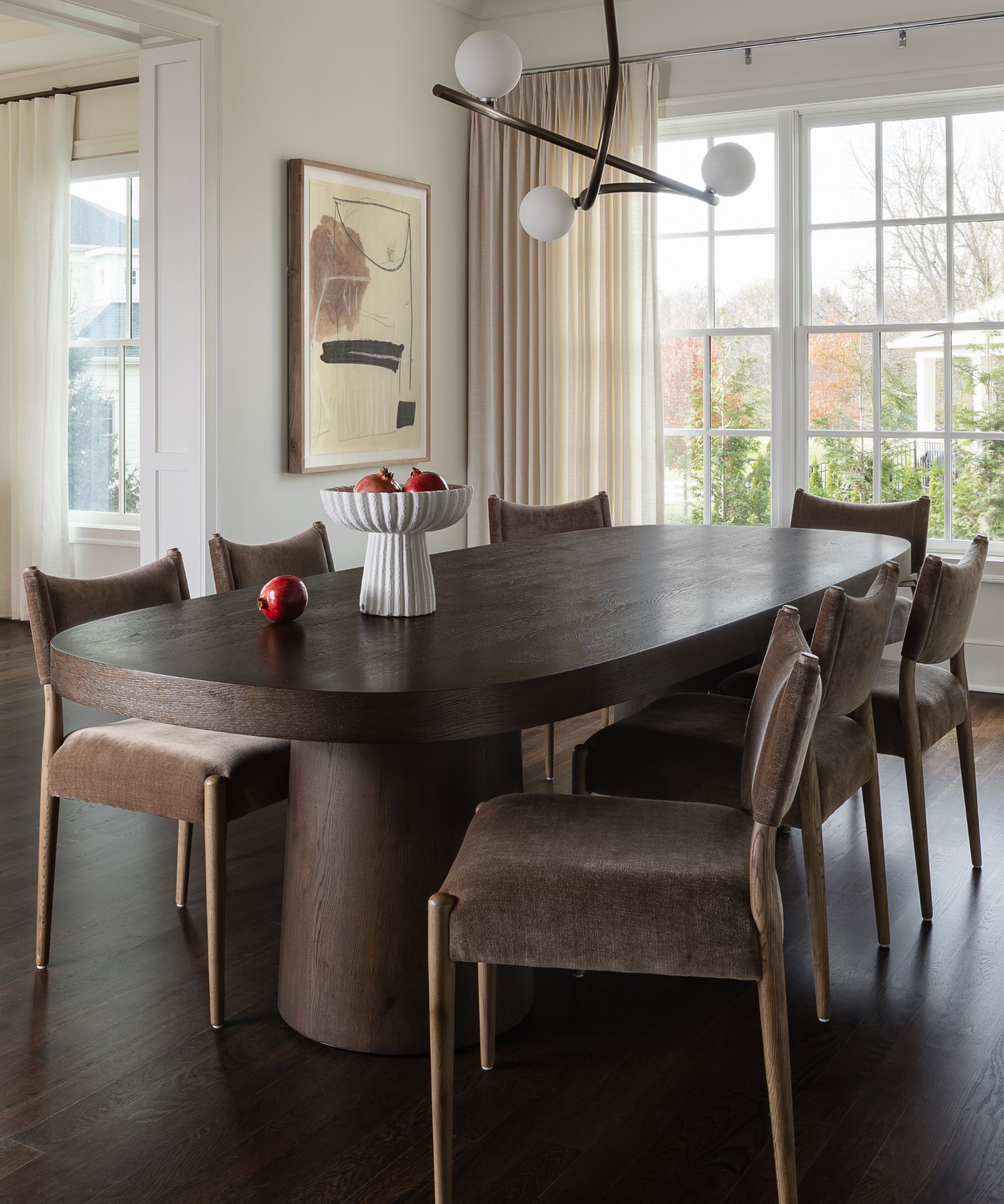 an open plan dining area in a home with large georgian windows and dark floors