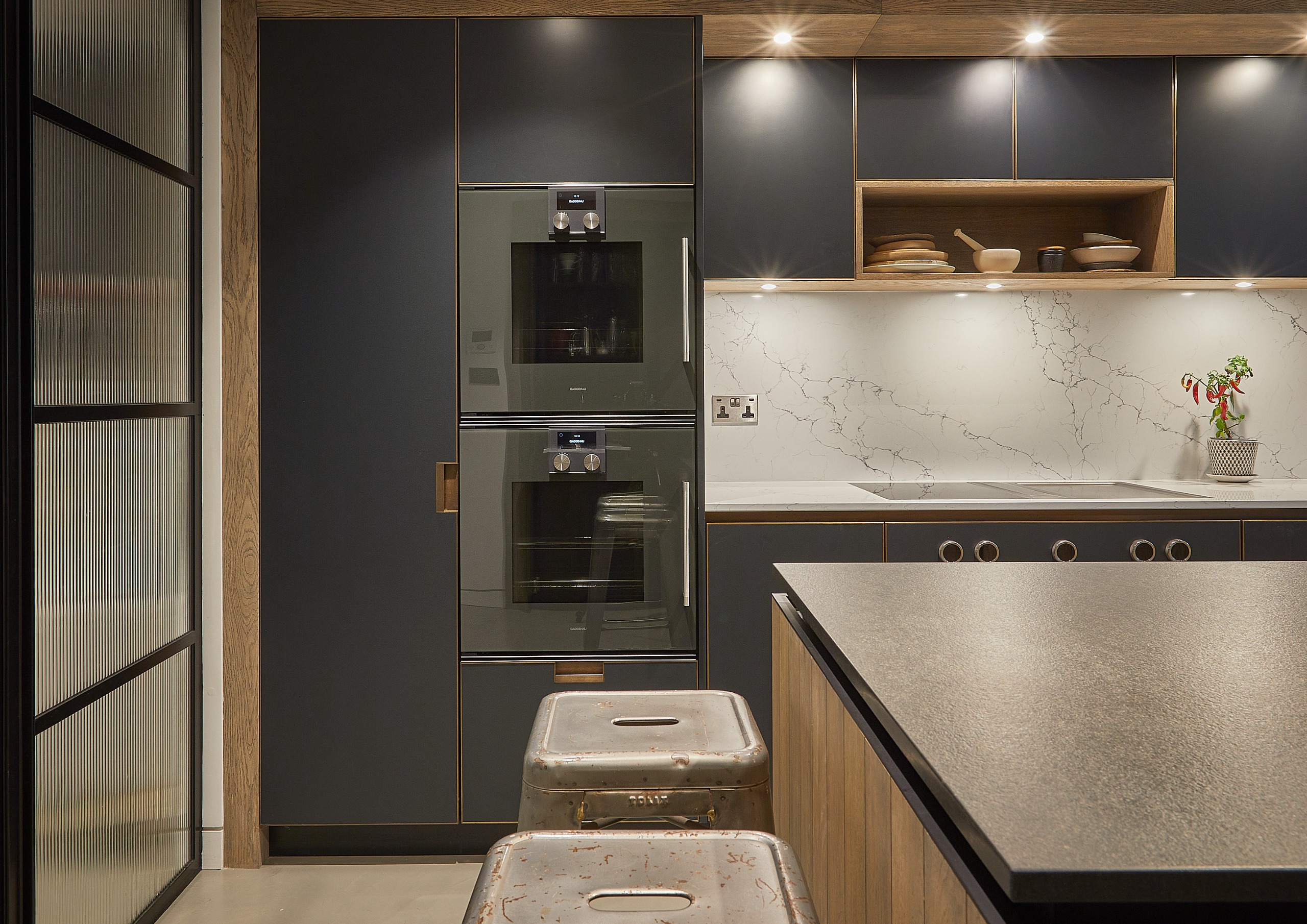 a dark kitchen with lights on and a texture island work surface