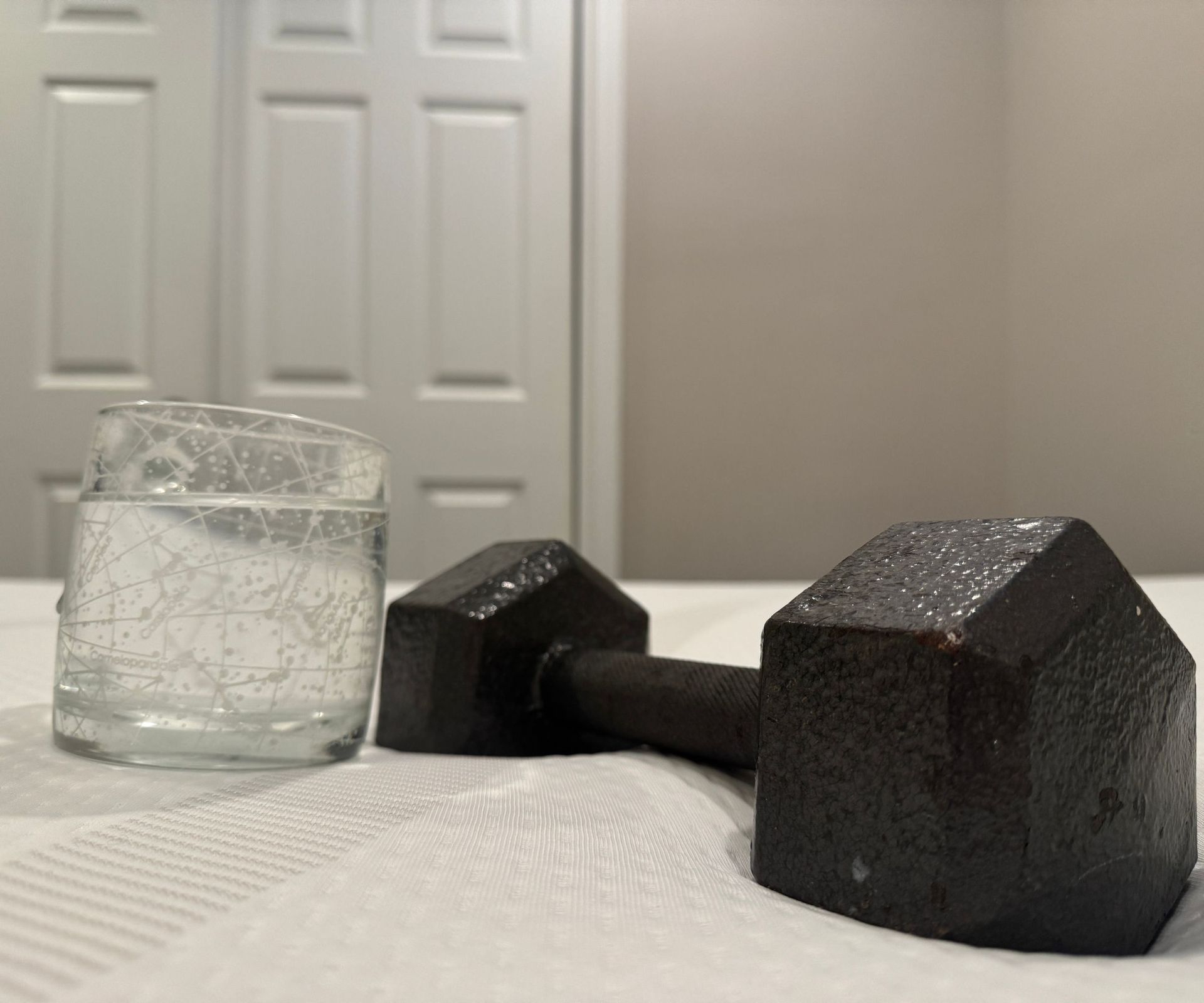 A glass of water and a dumbbell balanced on the TEMPUR-Cloud mattress.