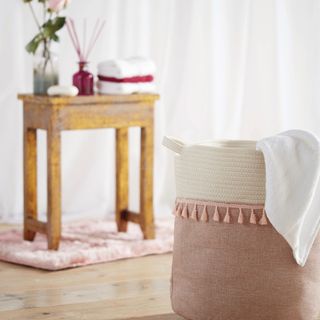room with pink and white designed basket and wooden table on wooden floor