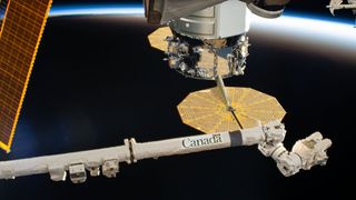 This photo shows the Canadarm2 robotic arm at the International Space Station which continues to orbit around Earth from 254 miles (409 kilometers) away. The robotic arm, a collaboration with Canada, helps to make repairs on the space station and astronauts have used it complete activities on spacewalks outside of the space station.