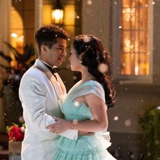 A coupe slow dances outside as snow falls in the evening.