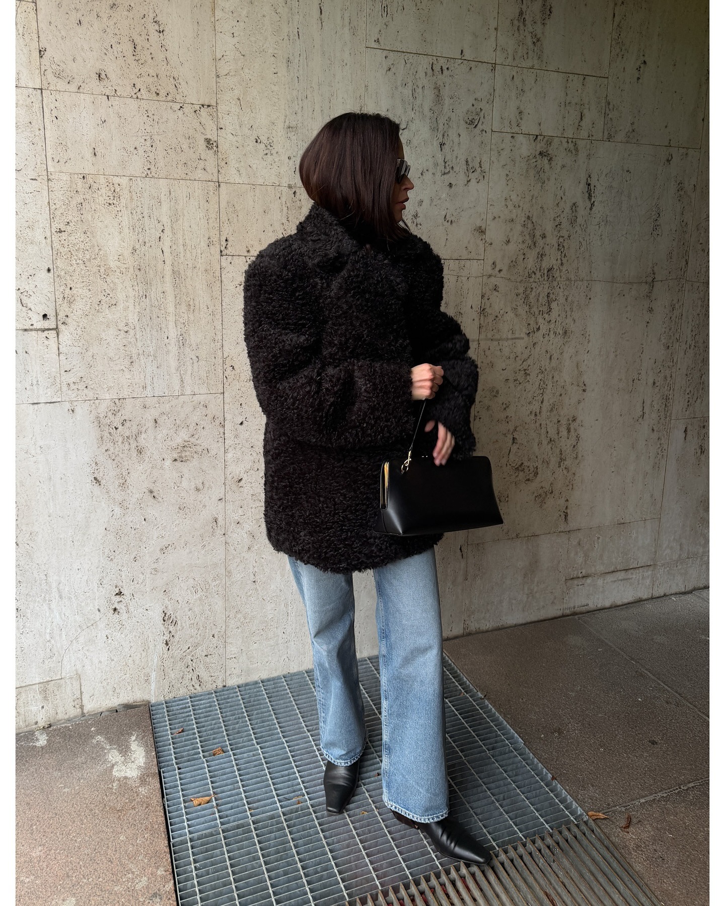 Woman wearing light wash jeans in winter.