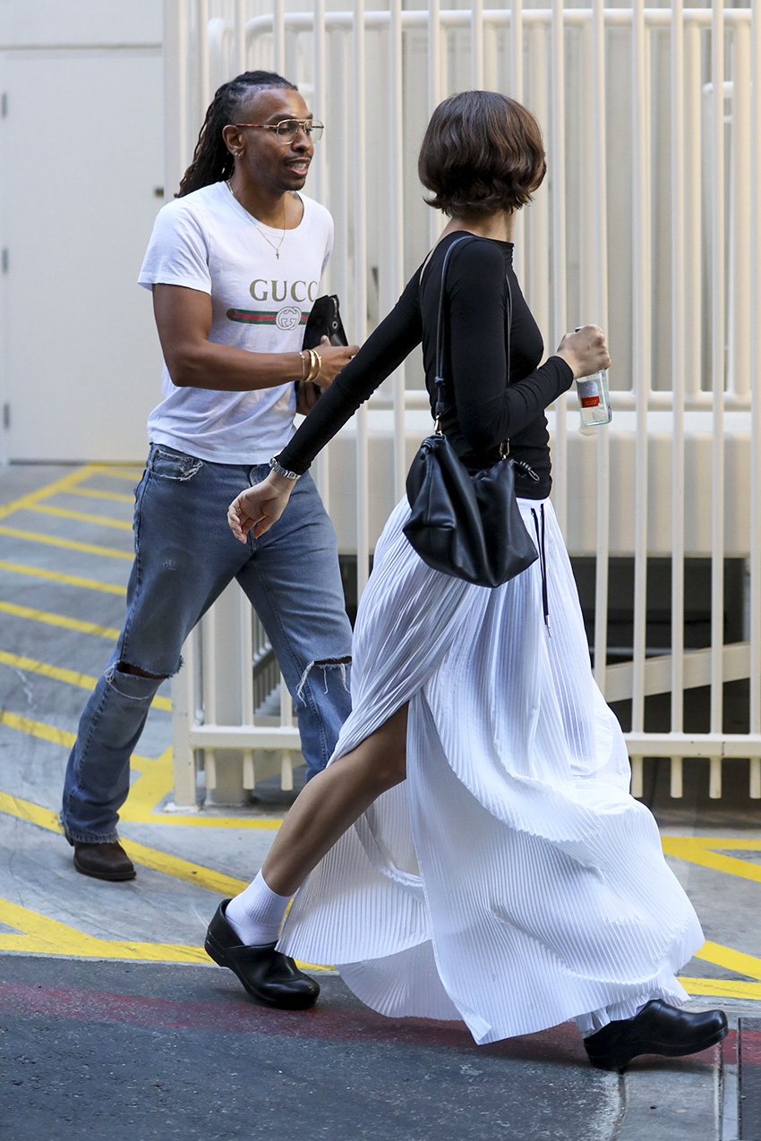 Tom Holland with Zendaya wearing a black top, white billowy pants, and black Dansko clogs