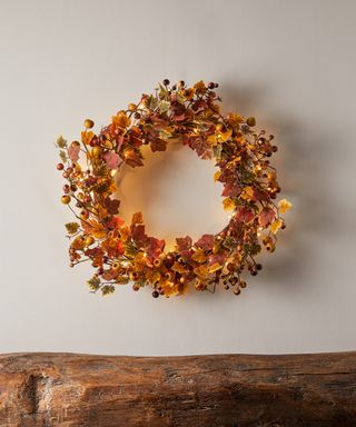Autumnal wreath hung on a white background