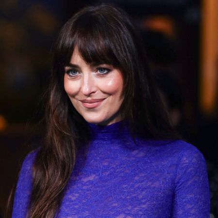 Dakota Johnson wears a bright blue gown on the red carpet in Zurich, featuring a drop waist silhouette and a sheer lace bodice