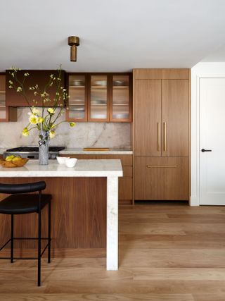 A sleek modern wood kitchen with marble countertops