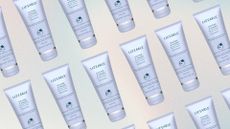 Repeating images of Liz Earle's purple tubes of Cleanse and Polish Relaxing Edition, on a pastel watercolour background