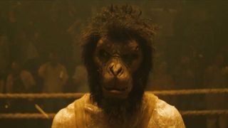 a man (dev patel) wears a monkey mask while standing in a boxing ring, in the film 'monkey man'