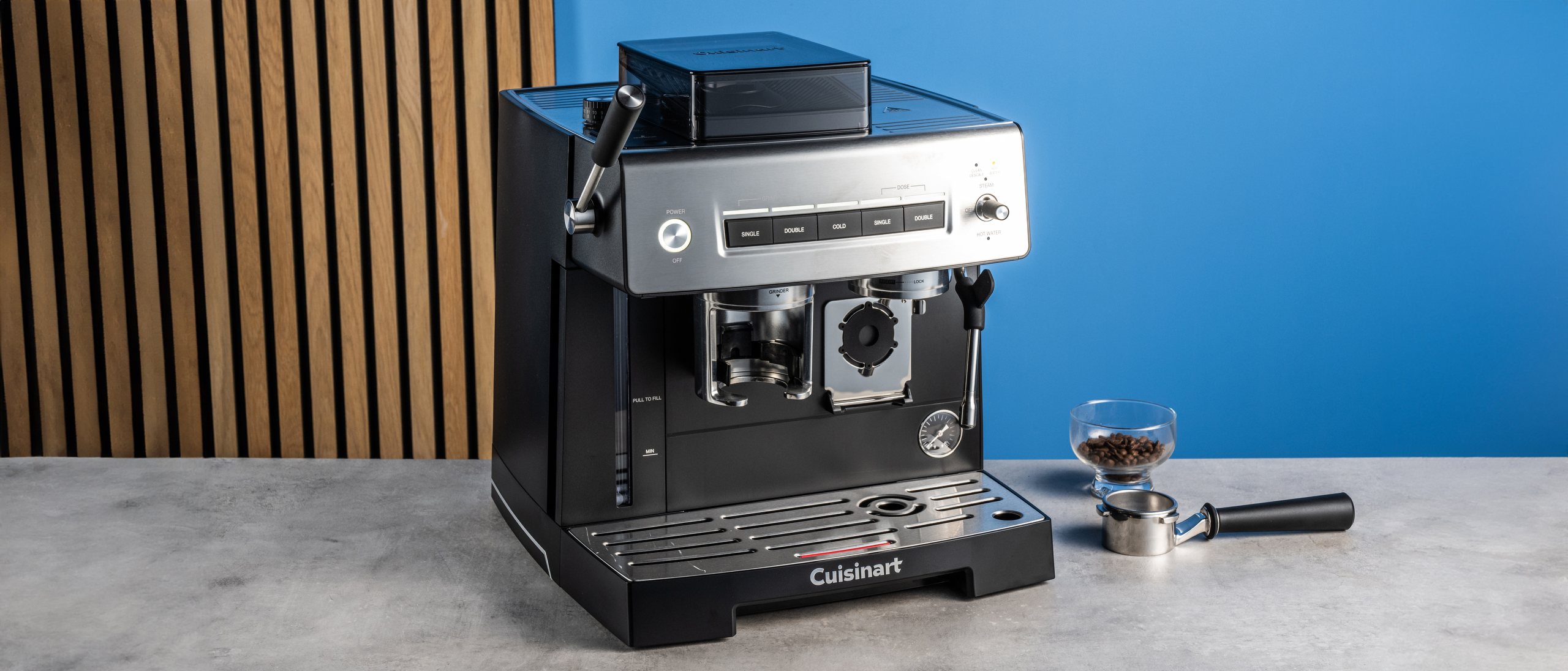 the cuisinart grind, tamp and brew espresso machine with built-in grinder photographed against a blue tom's guide background