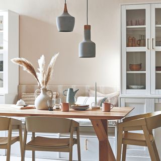 A Scandi dining room with a set dining table and low pendant lights