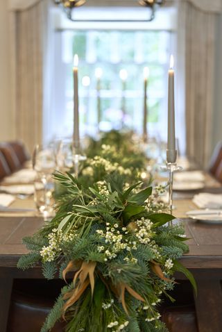 Christmas table garland with foliage , candles, tableware